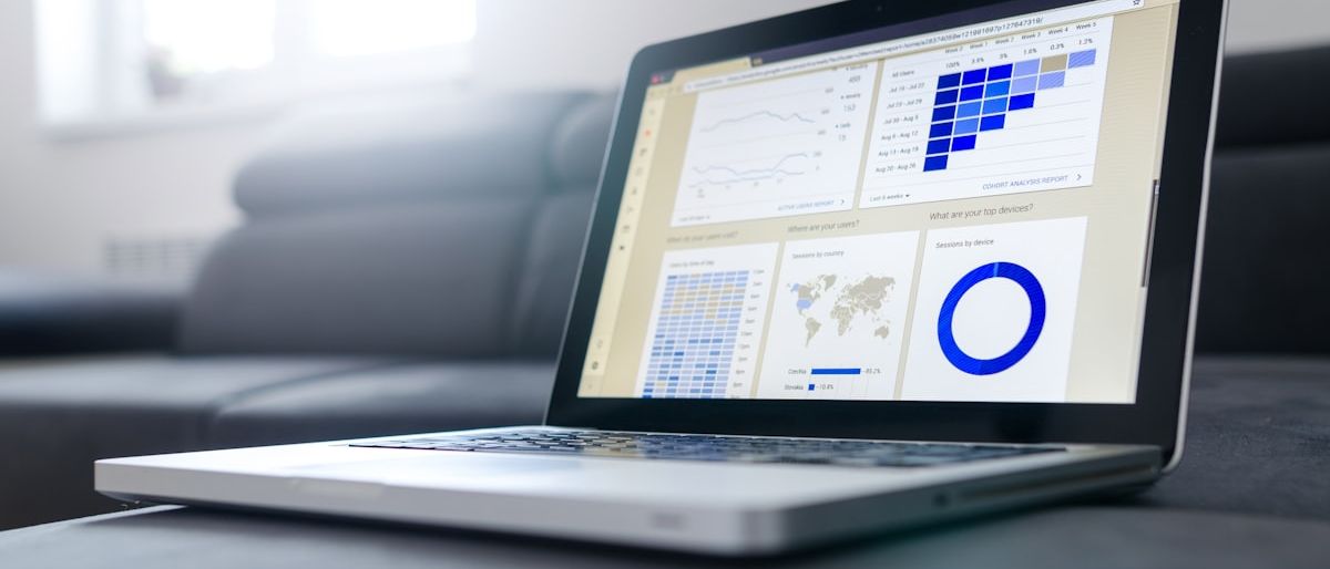 Person arbeitet an mehreren Bildschirmen mit Datenanalysen